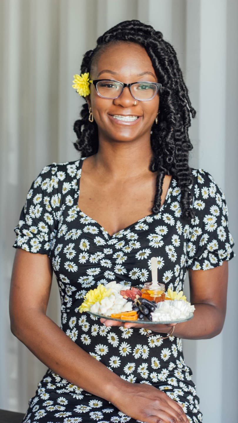 The owner of Meat & Graze smiling and holding a graze